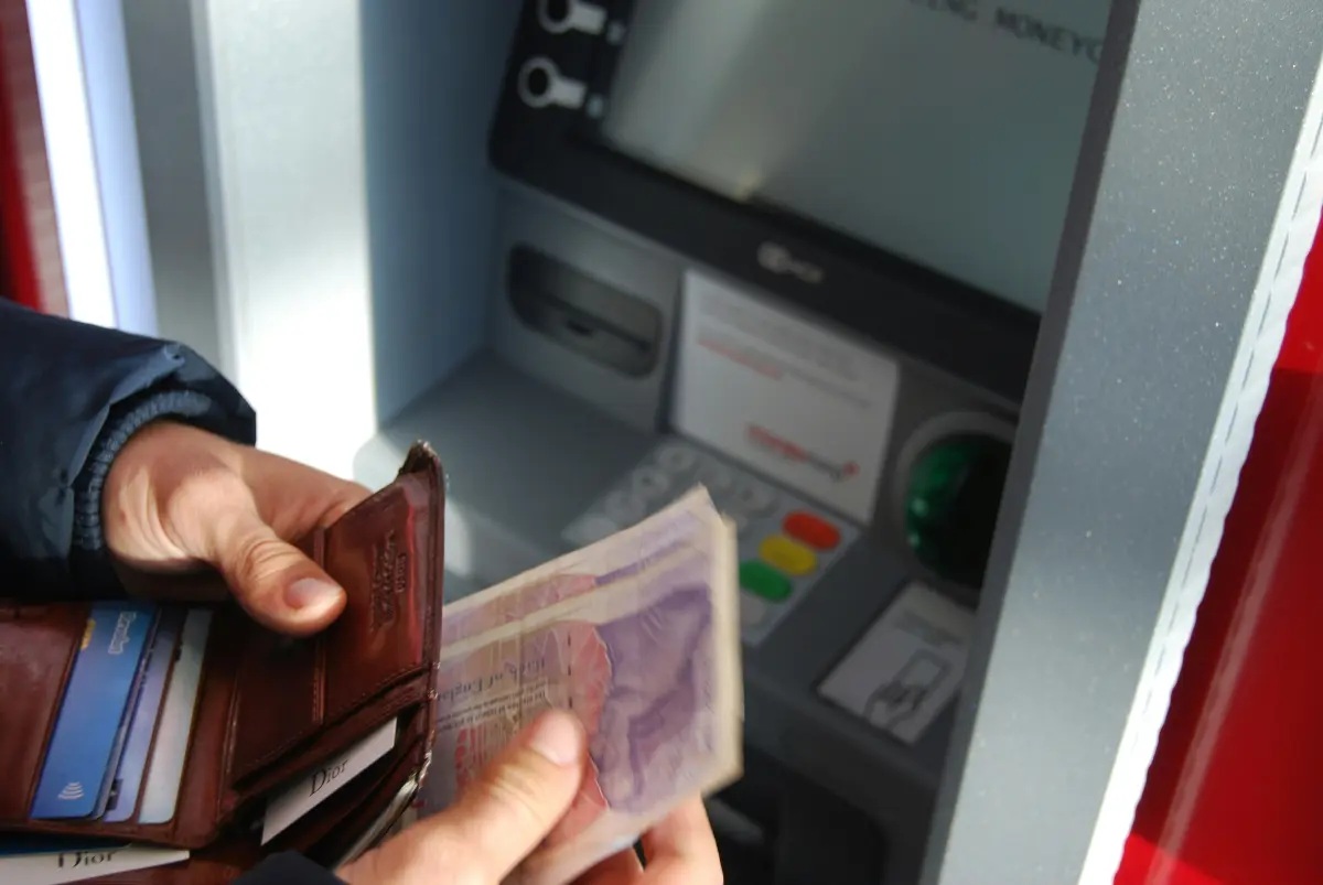 Traveler exchanging foreign currency at bank ATM